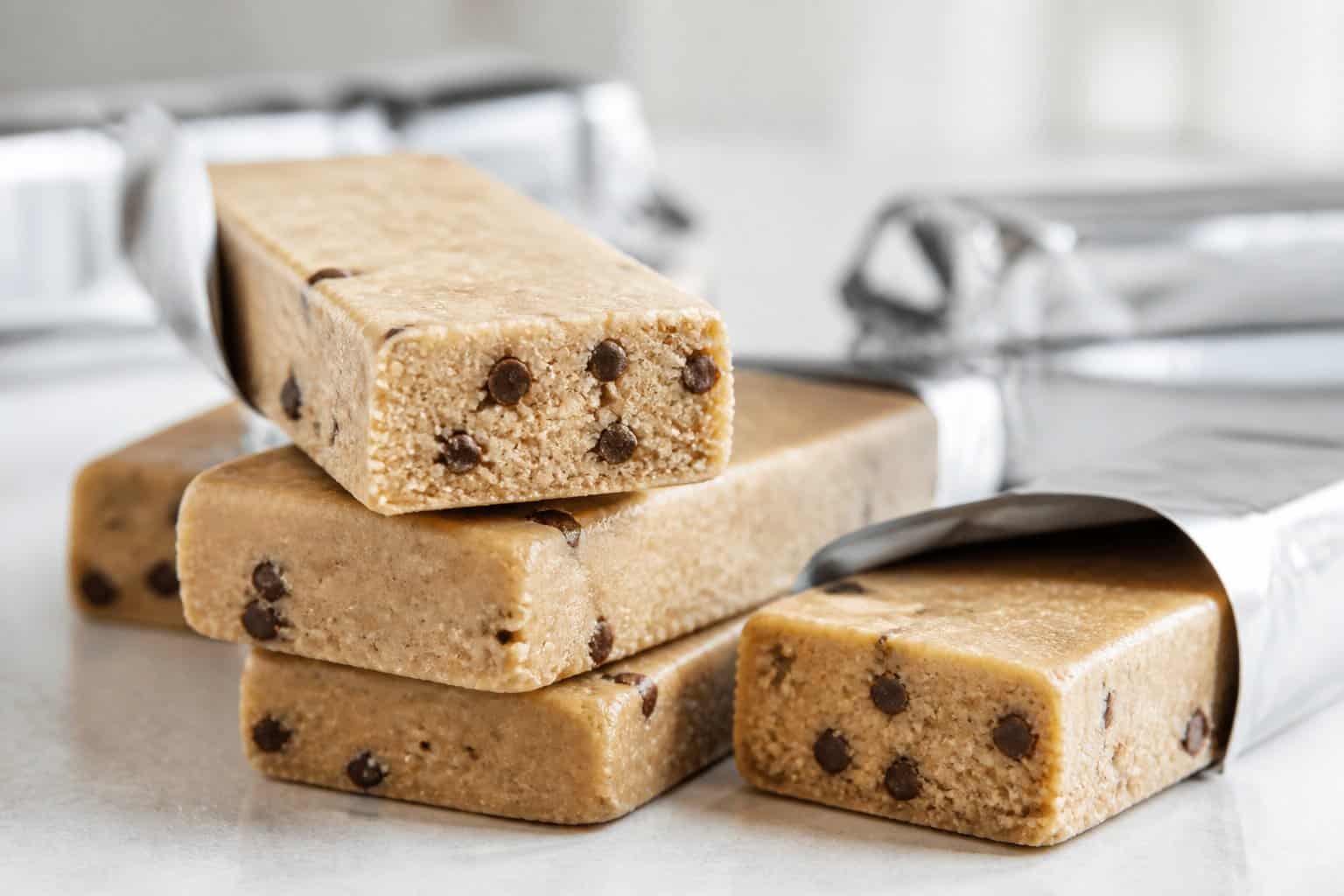 Close-up of several Kirkland Signature protein bars with a chalky texture arranged on a light surface.