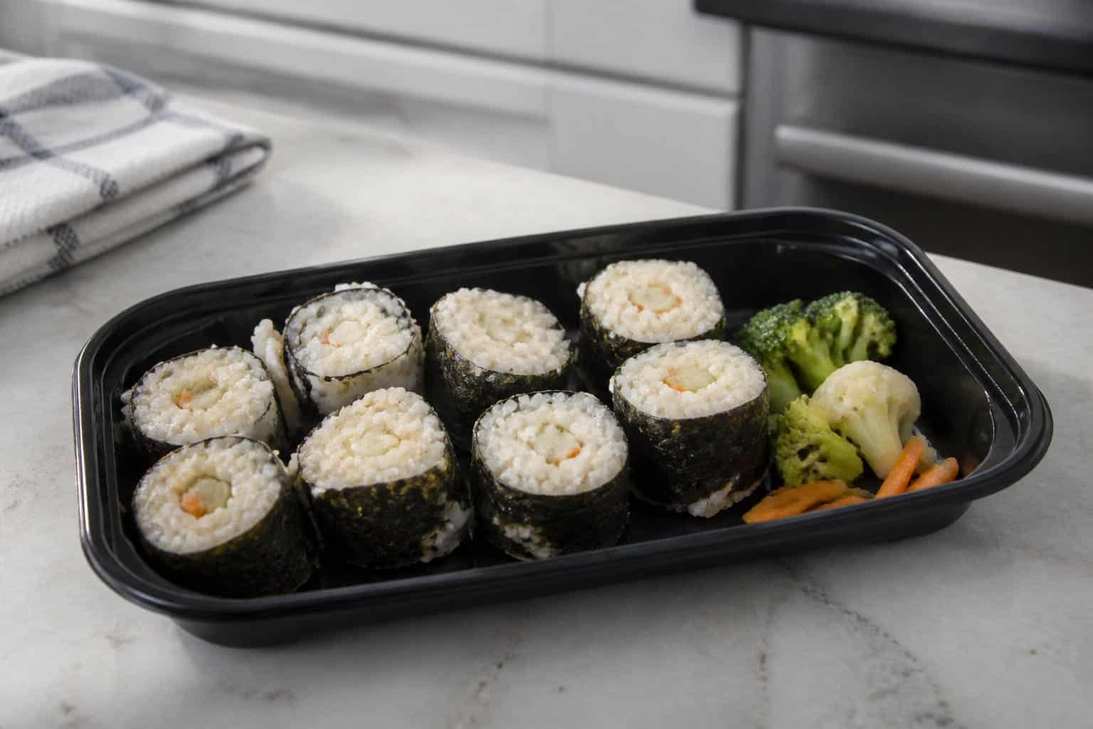 A bland-looking frozen sushi meal arranged on a kitchen counter.