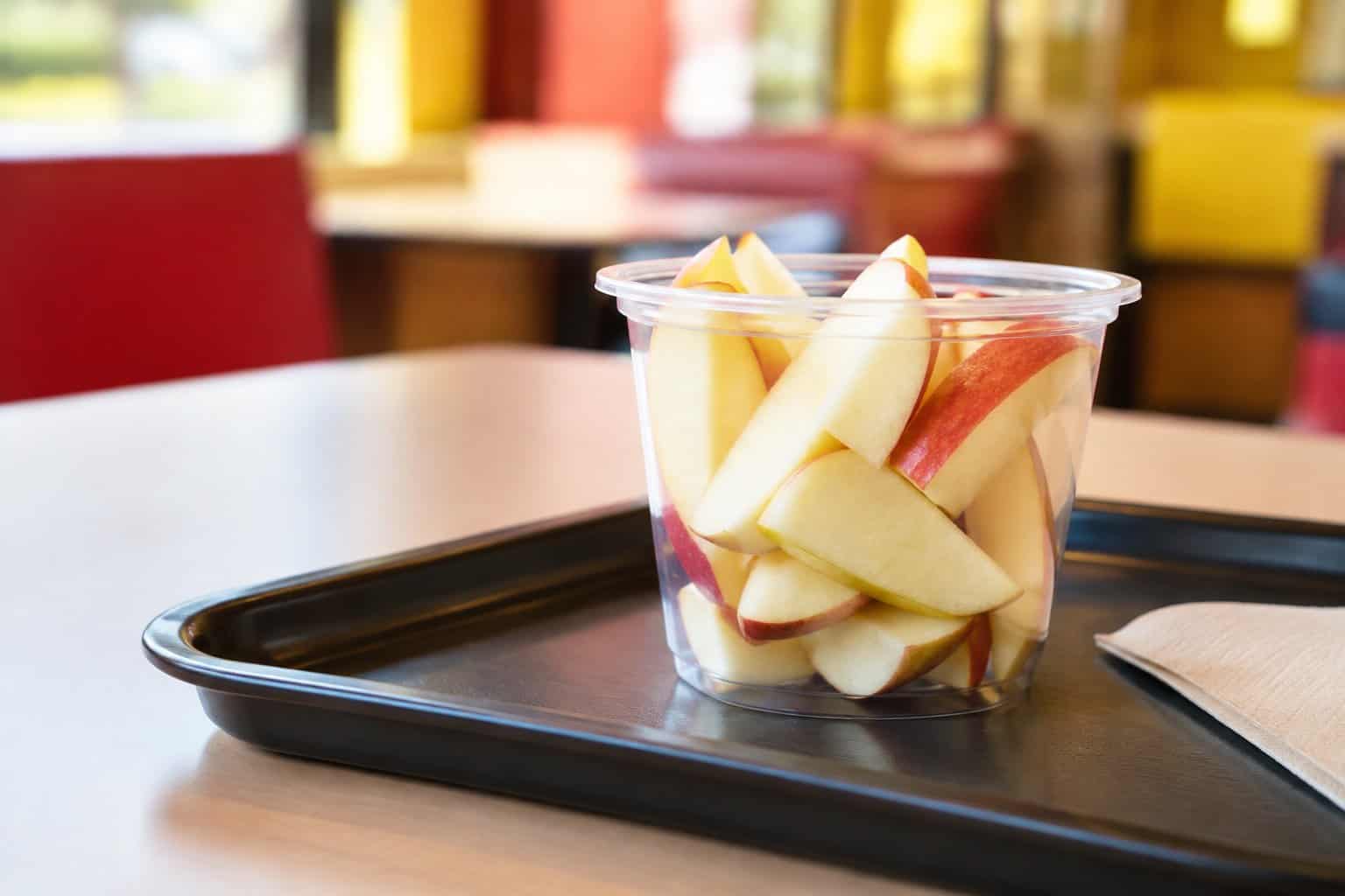A serving of sliced apples on a fast-food tray.